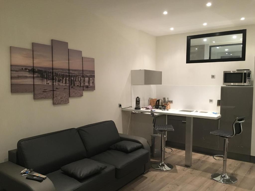 ein Wohnzimmer mit einem Sofa und einem Tisch sowie eine Küche in der Unterkunft Gallo in Nizza