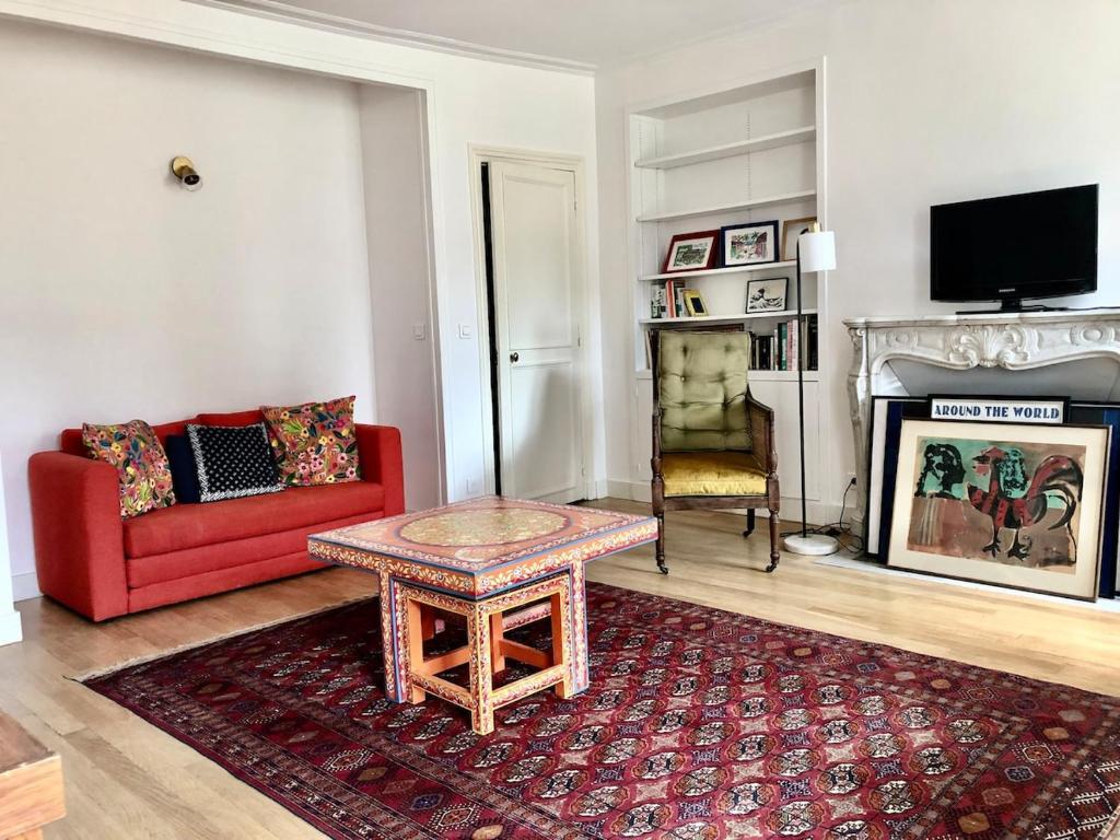 - un salon avec un canapé rouge et une cheminée dans l'établissement Large 5P apartment in Paris 5 Cuvier, à Paris