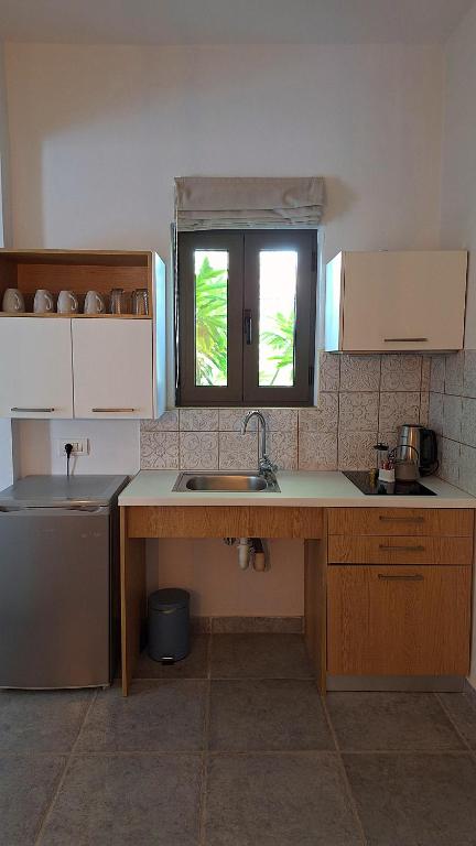 a kitchen with a sink and a window in it at Margo Beach Hotel in Gythio