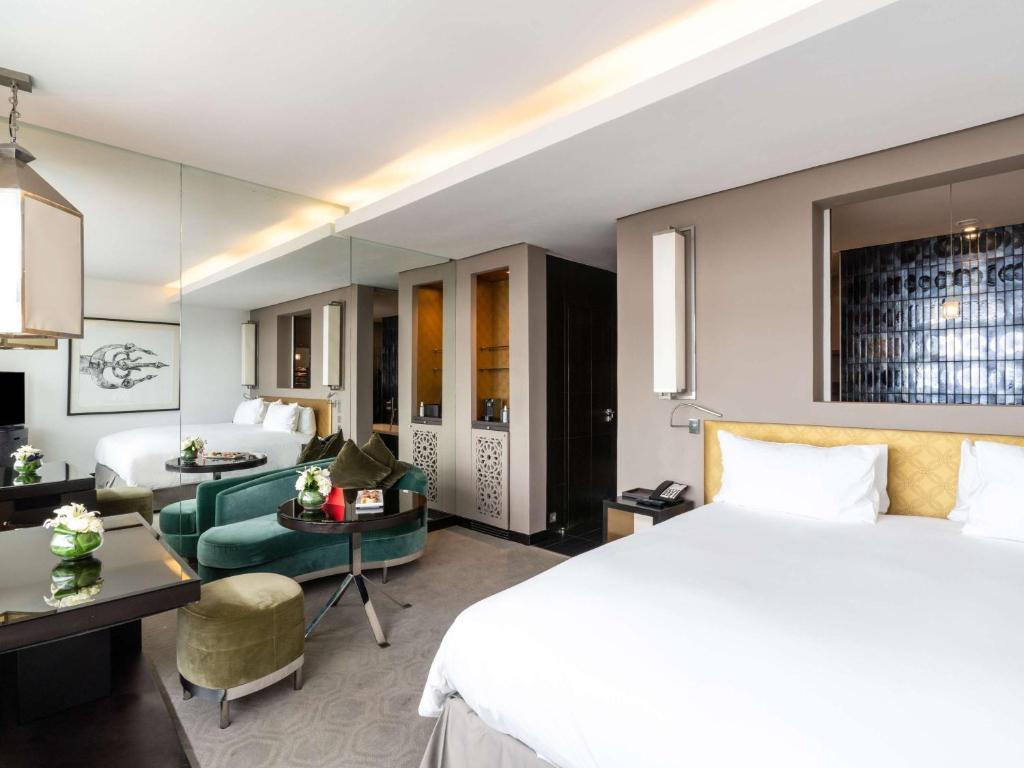 a hotel room with a bed and a living room at Sofitel Casablanca Tour Blanche in Casablanca
