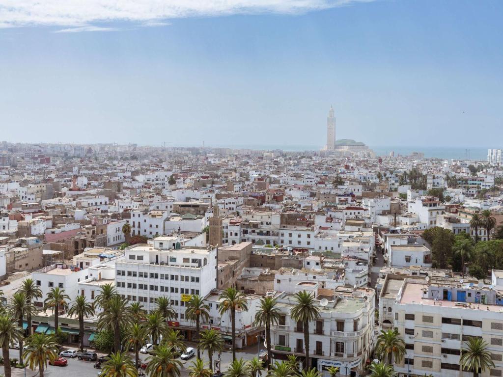 a view of a city with palm trees and buildings at Sofitel Casablanca Tour Blanche in Casablanca