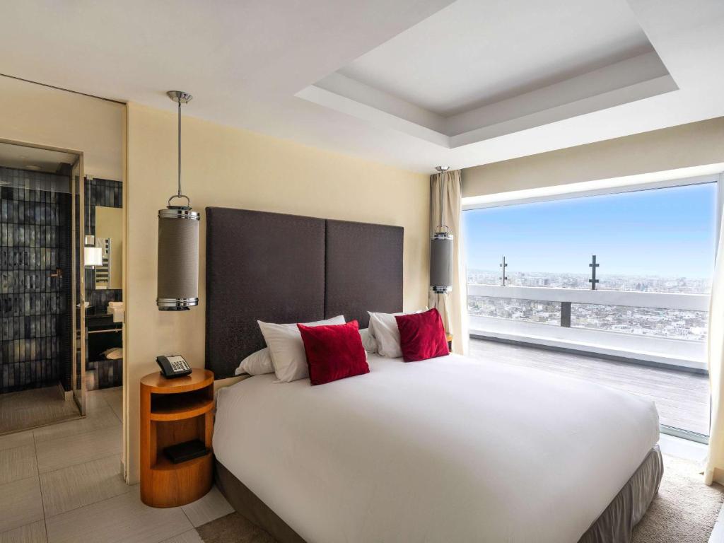 a bedroom with a large bed with a large window at Sofitel Casablanca Tour Blanche in Casablanca