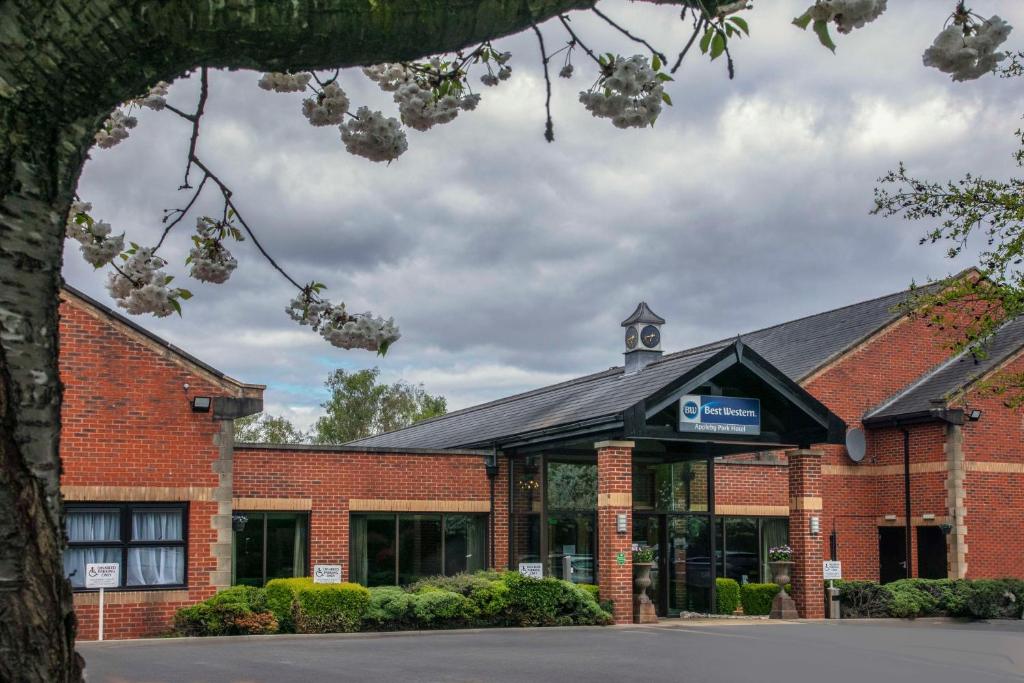 un edificio de ladrillo rojo con una torre de reloj en la parte superior en Best Western Appleby Park Hotel, en Tamworth