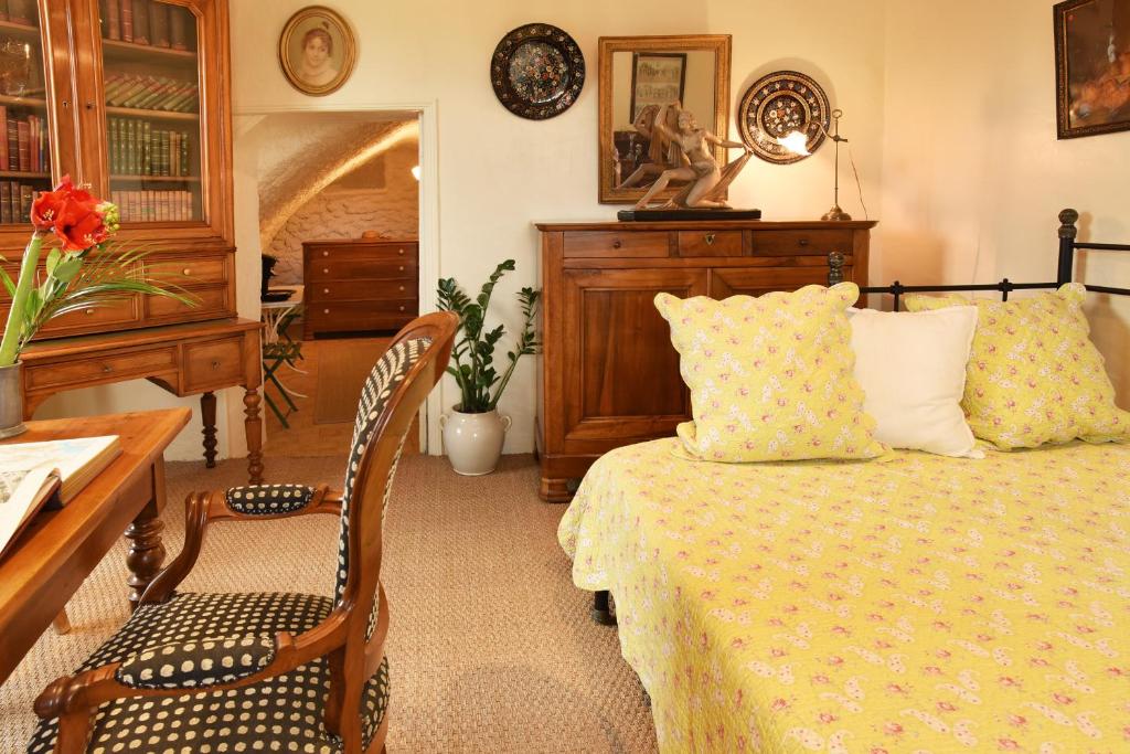 1 dormitorio con 1 cama, mesa y sillas en Chez L'Antiquaire, en Hauterives