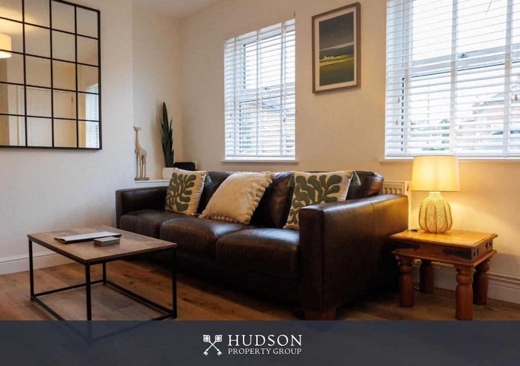 Una sala de estar con un sofá de cuero marrón y una mesa. en 3 Bedroom Home in Wellington, en Wellington