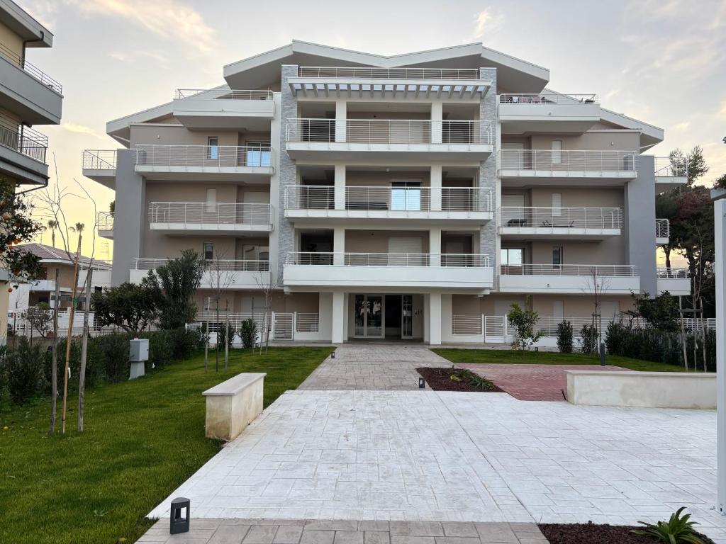 an apartment building with a lawn in front of it at VINCI - Narramondo Villas in Tortoreto Lido