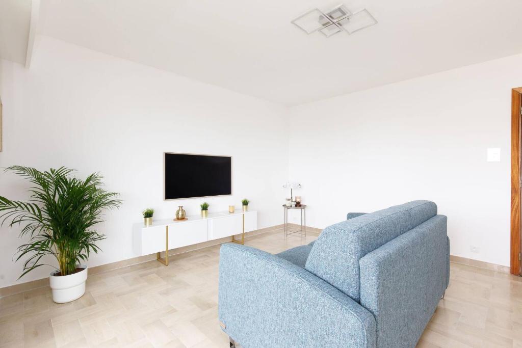 un salon avec un canapé bleu et une télévision dans l'établissement Juan les pins Studio détente Vacances & Mer, à Juan-les-Pins