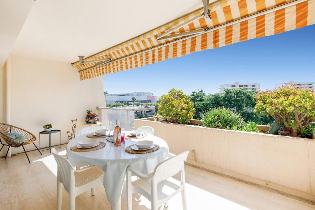 une salle à manger blanche avec une table et des chaises sur un balcon dans l'établissement Echappée paisible à Antibes, à Antibes