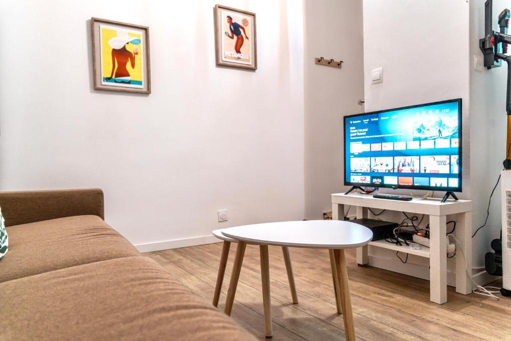 un salon avec un canapé et une table avec une télévision dans l'établissement Charmant Studio Vieux Port, à Marseille