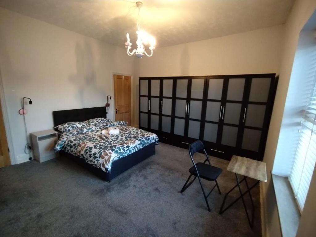 a bedroom with a bed and a chair and a chandelier at Double-Bed Manchester Close To Bolton City Centre C2 in Little Hulton