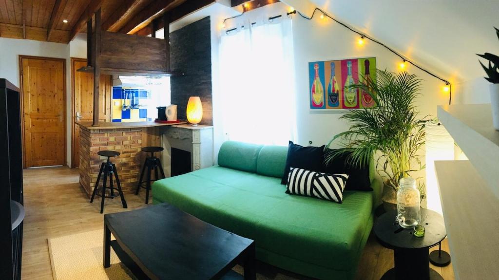 un salon avec un canapé vert et une cuisine dans l'établissement Apartment Saclay 2 near HEC, Versailles, à Saclay