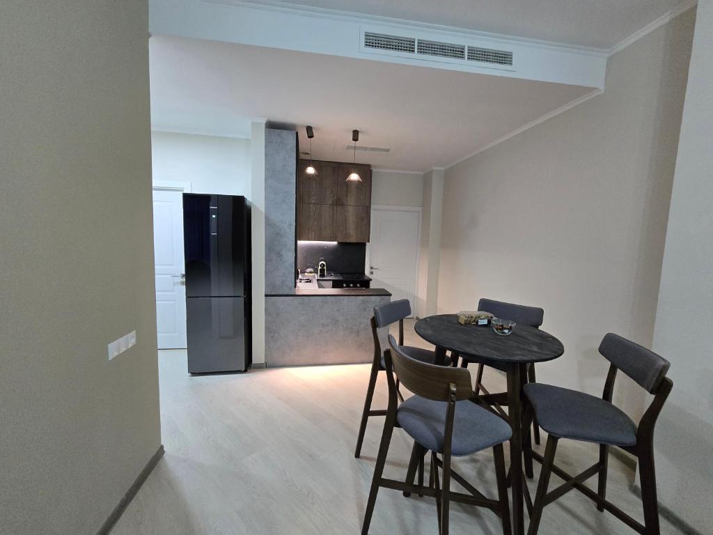 una cucina con tavolo, sedie e frigorifero di Апартаменты a Tsaghkadzor