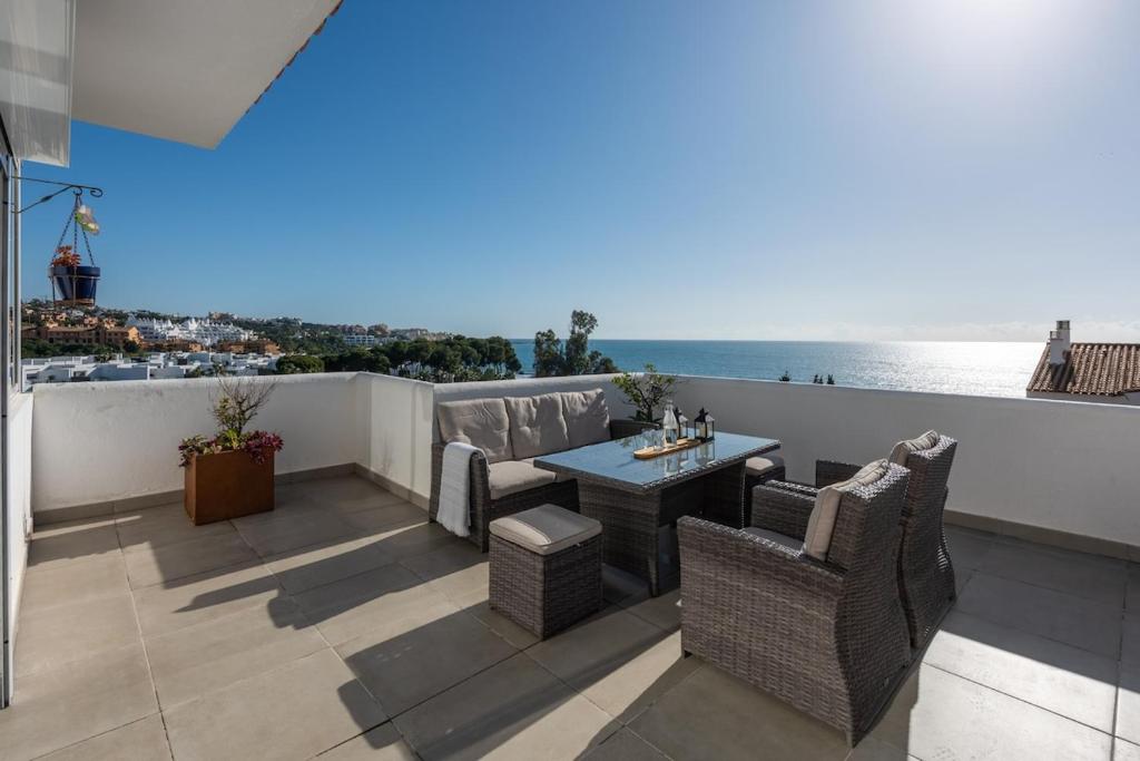 a patio with a table and chairs and the ocean at Stunning Beachfront Penthouse in Estepona