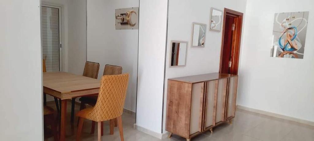 Un comedor con mesa y sillas de madera. en VILLA midoun, en Taguermess