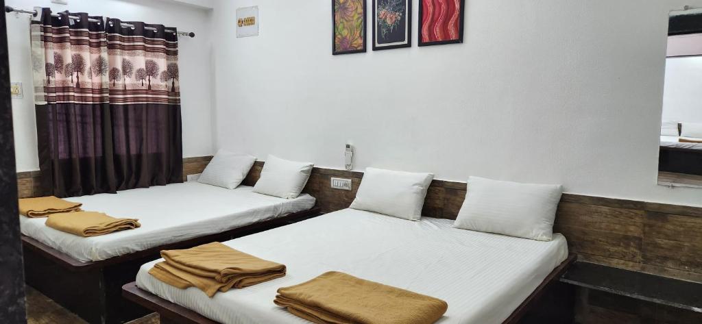 two beds in a room with towels on them at Gotawala Villa 11 in Daman