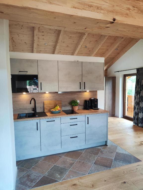 a kitchen with white cabinets and a sink at Chiemseehof in Prien am Chiemsee