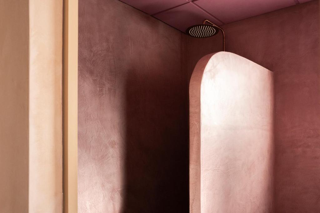 a hallway with a pink wall and a light at Formentera Especial in La Savina