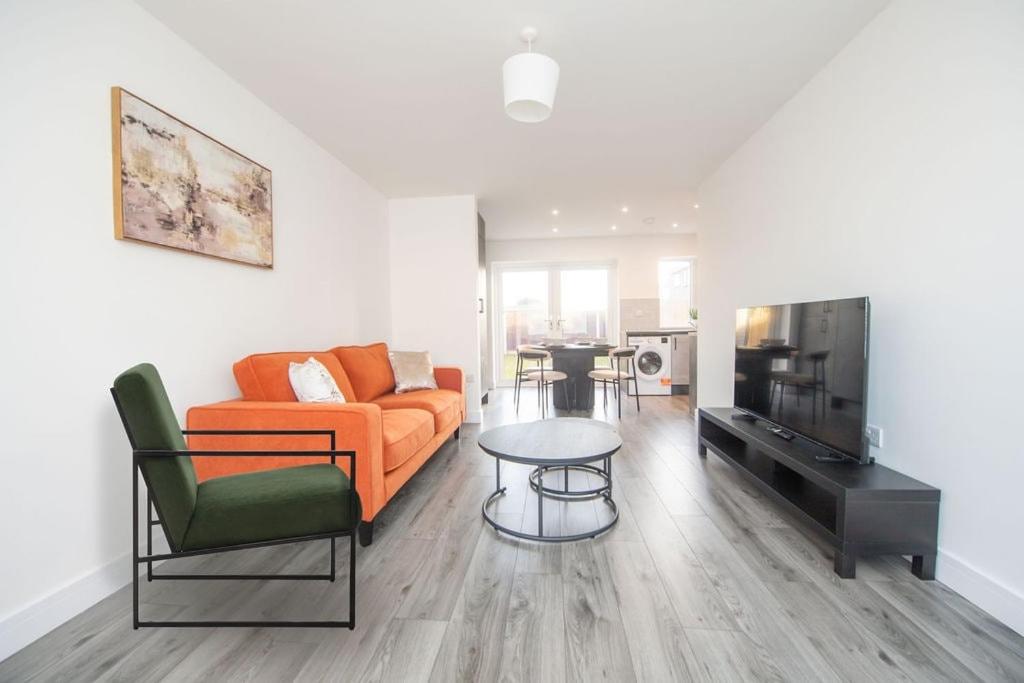 a living room with an orange couch and a table at Stylish 3-Bed Home-Liverpool in Liverpool