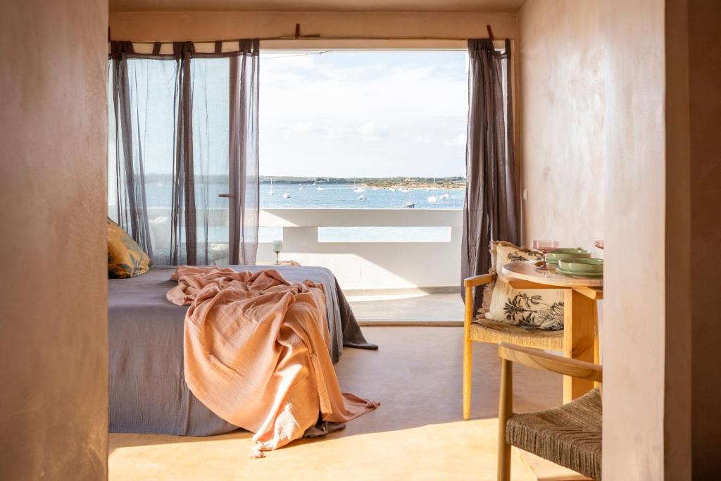 a bedroom with a bed with a view of the ocean at Formentera Especial in La Savina