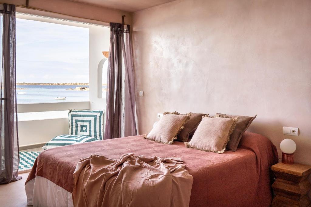 a bedroom with a bed with a large window at Formentera Especial in La Savina