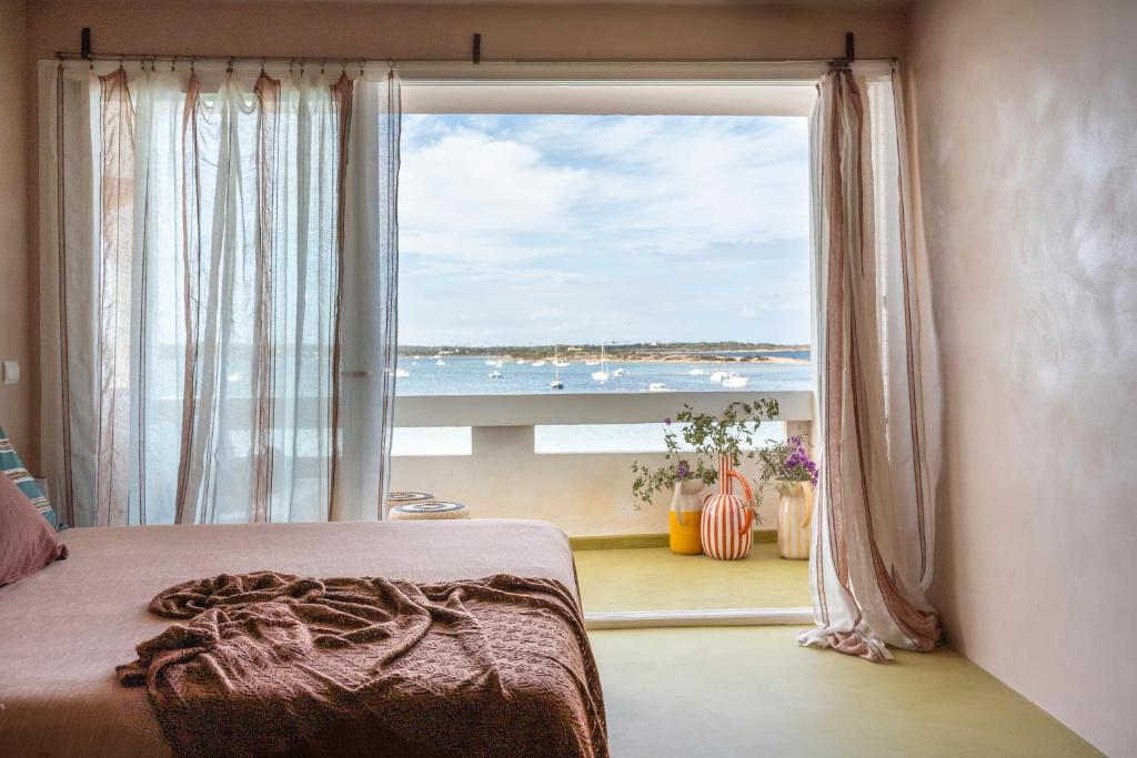 a bedroom with a large window with a view of the ocean at Formentera Especial in La Savina