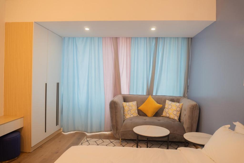 a living room with a couch and a table at Laurell Hill Suites, Upper Hill in Nairobi