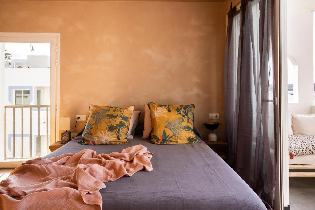 a bedroom with a bed with blue sheets and a window at Formentera Especial in La Savina