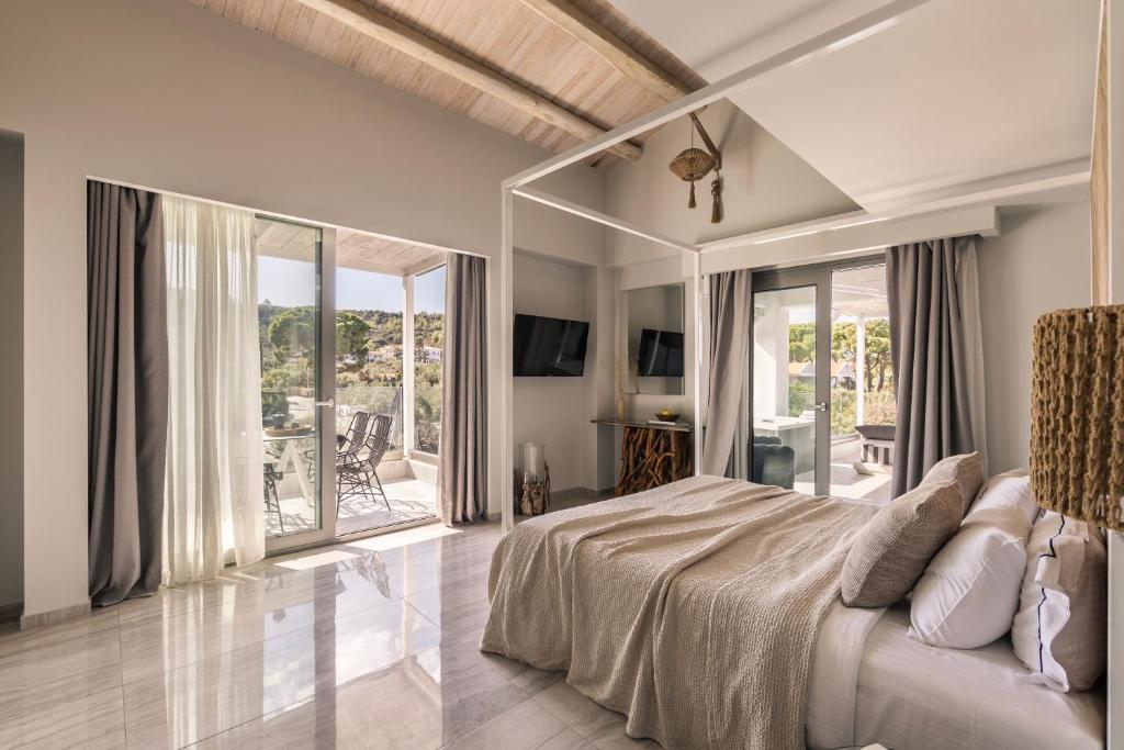sypialnia z dużym łóżkiem i balkonem w obiekcie Blue Carpet Luxury Suites w mieście Pefkochori