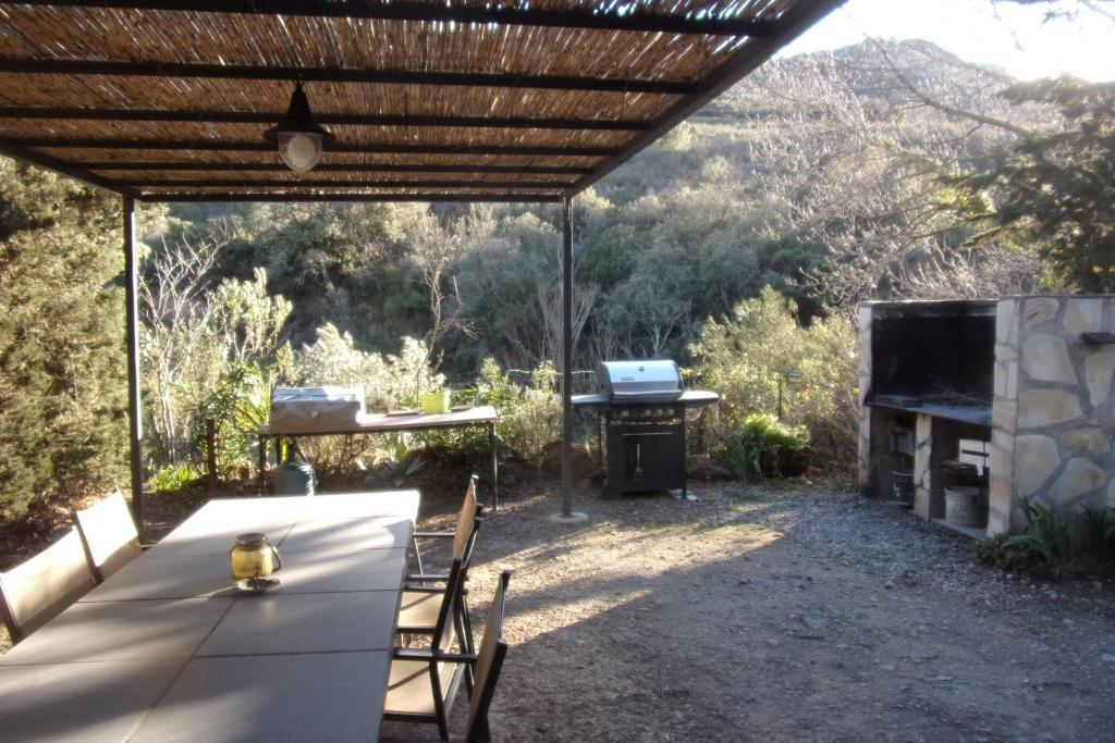 a table and chairs under a pergola with a grill at DOMAINE LE PLA de LIÉRE in Maury