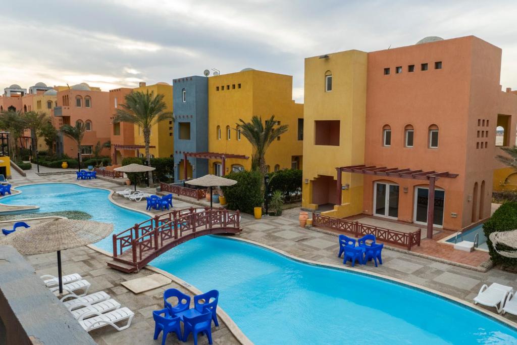 a resort with a pool and chairs and buildings at Al-Dora Resort Hurghada in Hurghada