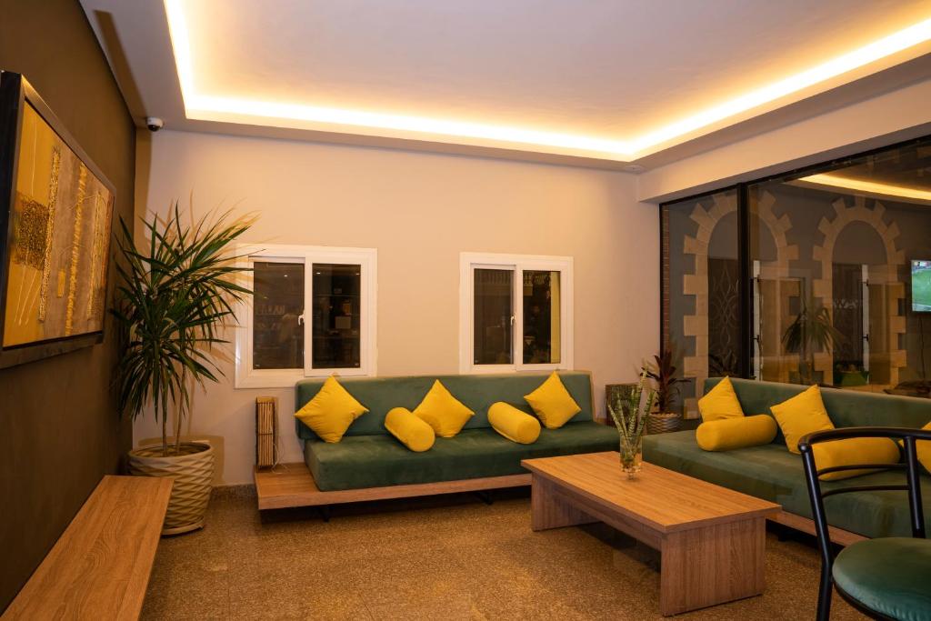 a living room with a green couch with yellow pillows at Al-Dora Resort Hurghada in Hurghada