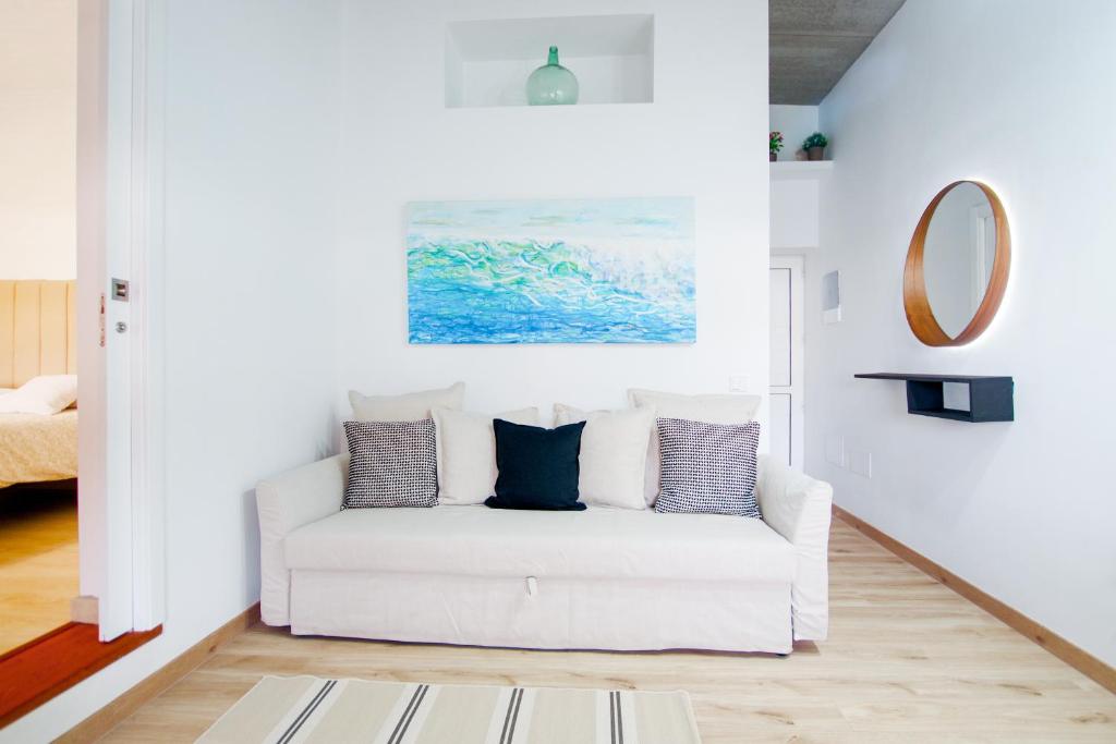 a white couch in a living room with a mirror at Serenity House in Tinajo