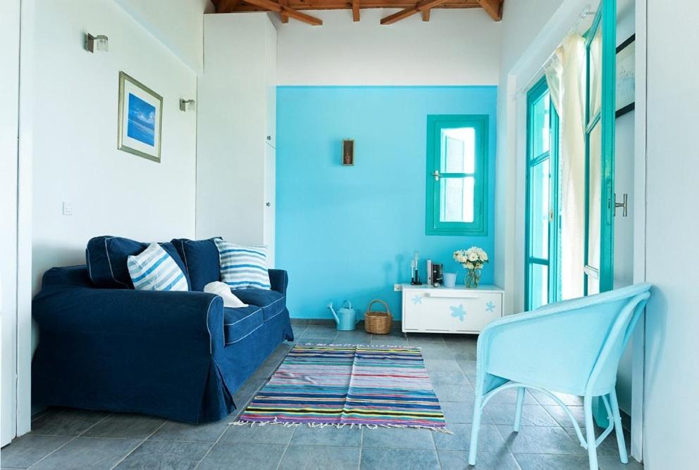 a living room with a blue couch and a chair at The Iconpainter Marathi Villa in Kómboi