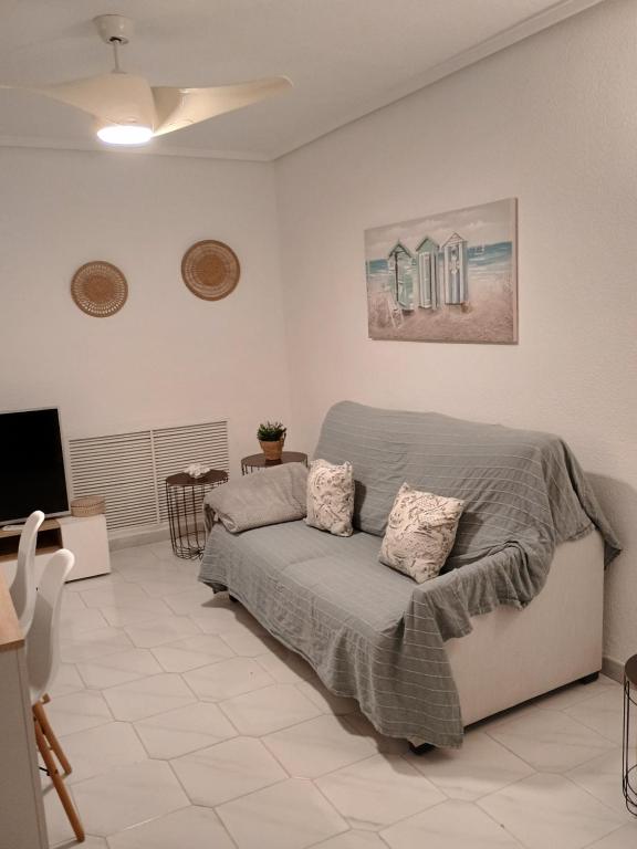 Un dormitorio con una cama y un televisor de pantalla plana. en Apartamento en la playa de Cala Capitán -Cabo Roig- Orihuela Costa, en Orihuela