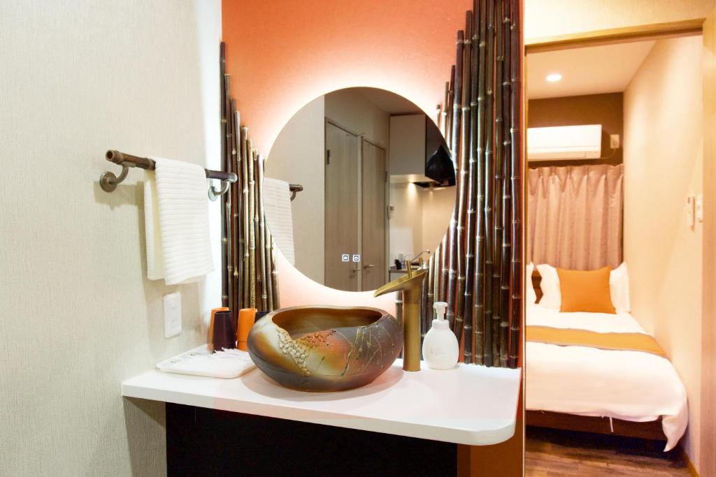 a bathroom with a sink and a mirror at 楓の宿1号館 in Osaka