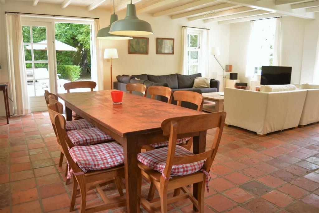 a living room with a wooden table and chairs at DE103 - Charming farm style home on a large estate in Domburg