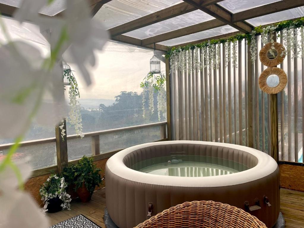a hot tub in a room with a window at Refúgios do Rio Dão in Mangualde