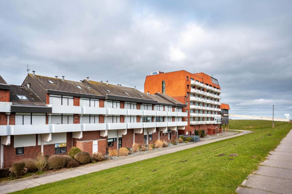 a row of buildings on a street with grass at Ferienwohnungen Meer-Schillig in Wangerland