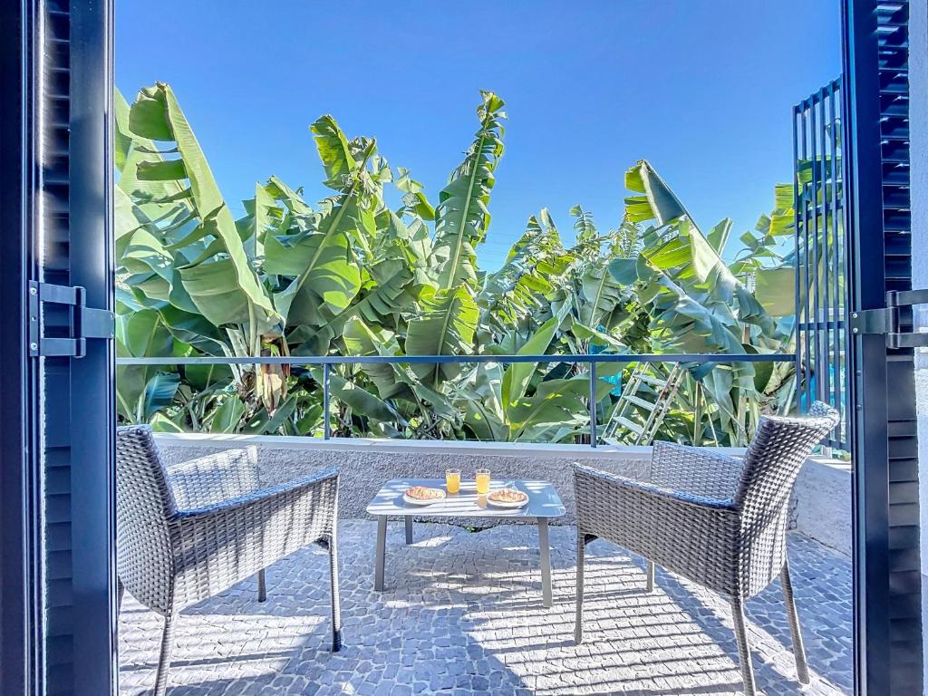 a patio with two chairs and a table on a balcony at Madeiran Sweet Home in Panasqueira