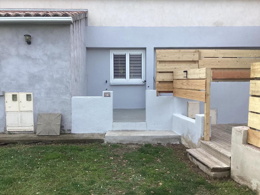 une maison blanche avec une porte et une cour dans l'établissement Saleccia, à Santa-Lucia-di-Moriani