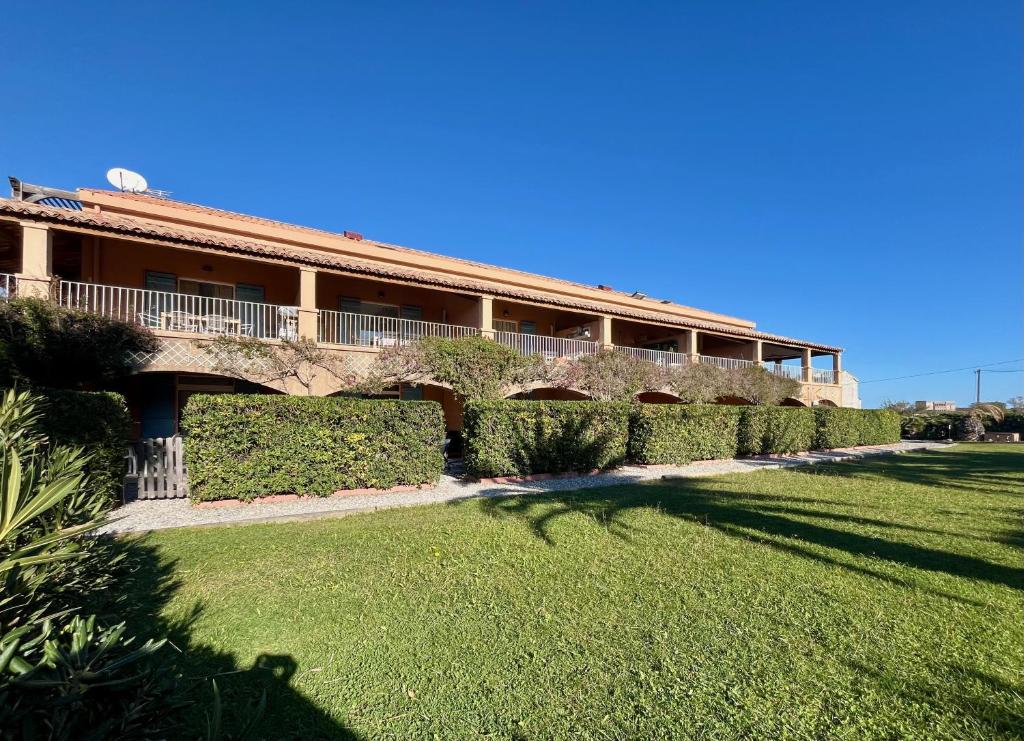 un bâtiment avec une pelouse devant dans l'établissement Studio Jade a 100m de la plage, à Hyères