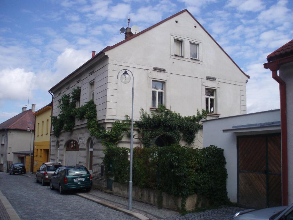 a white house with cars parked in front of it at Apartmán Skalka in Mnichovo Hradiště