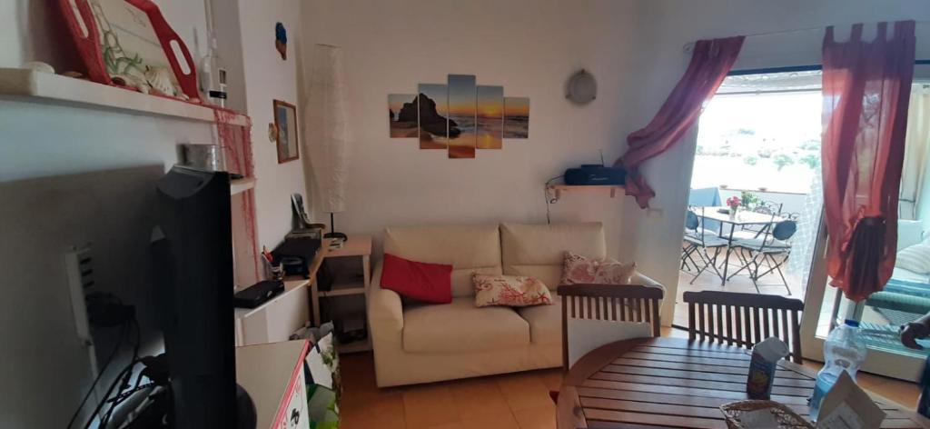 salon z kanapą i krzesłem w obiekcie Sardegna casa al mare San Teodoro Vaccileddi Porto San Paolo w mieście Porto San Paolo