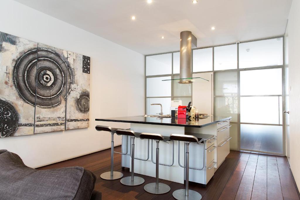 Una cocina con encimera y taburetes en una habitación. en Marnix360apartments Modern, en Ámsterdam
