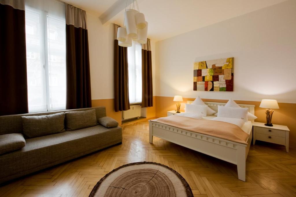 バンベルクにあるMonello Apartments - Charmanter Altbauのリビングルーム(ベッド1台、ソファ付)