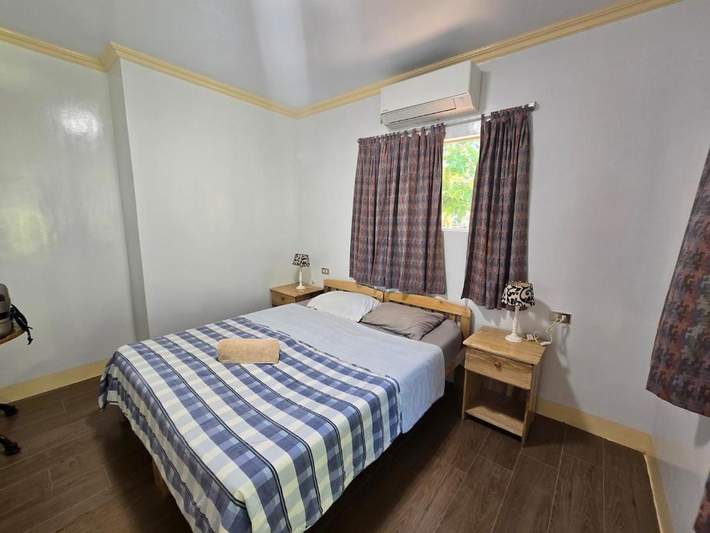 a bedroom with a bed with a blue and white checked blanket at Bregman Residance in Plaridel
