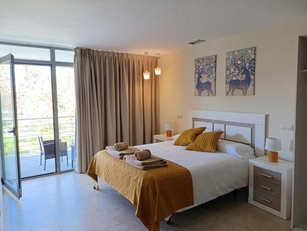 una camera da letto con un letto con asciugamani sopra di La Alameda Jardines del Prado -Amplio y con ascensor- a Talavera de la Reina