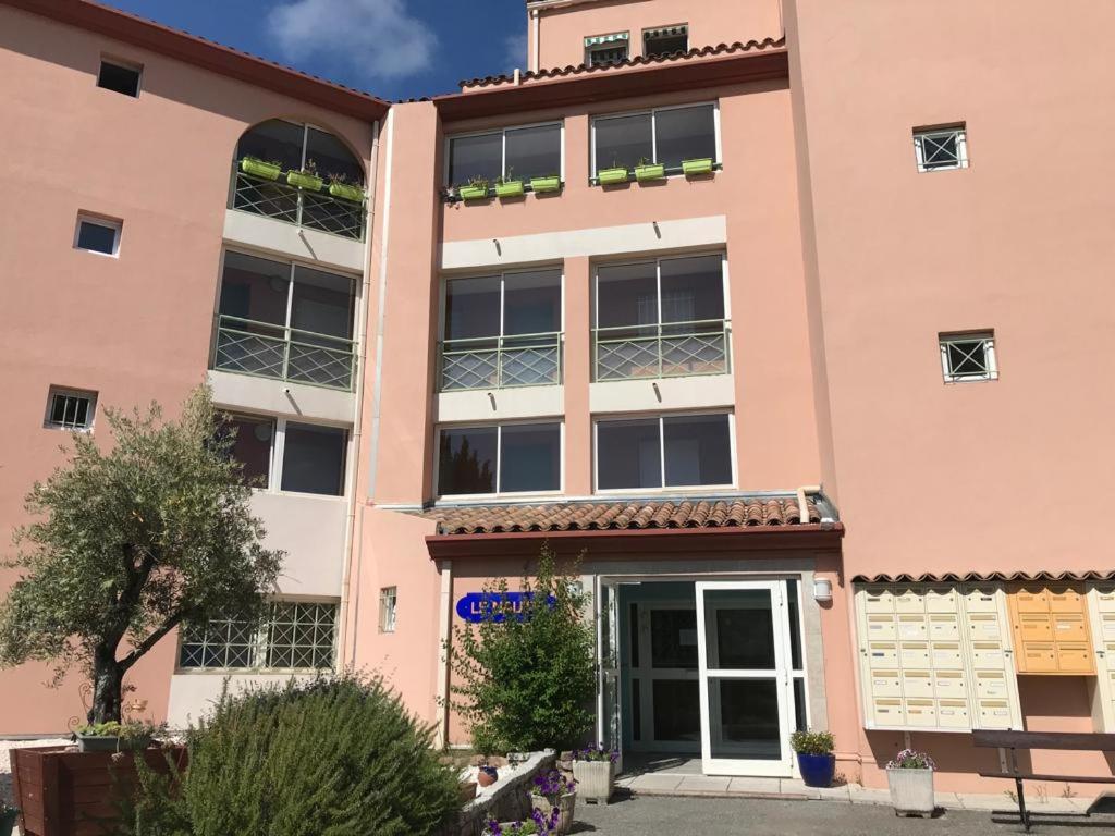 un immeuble d'appartements de couleur rose dans l'établissement appartement vue mer agay, à Agay