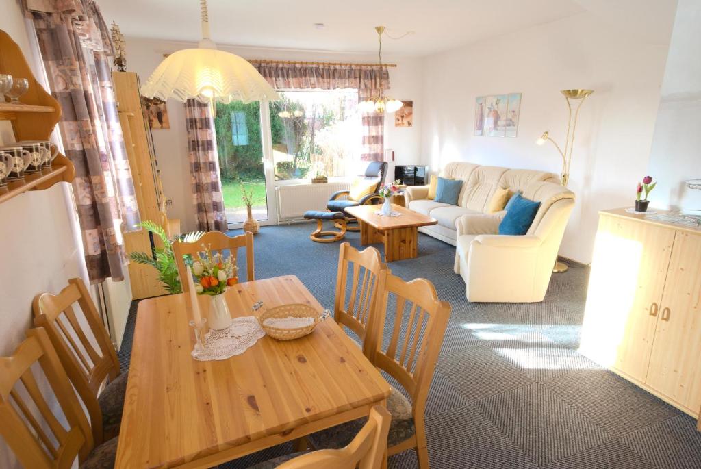 a kitchen and living room with a wooden table and chairs at Ferienhaus Gruber in Norddeich