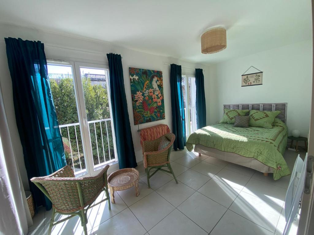 Schlafzimmer mit einem Bett, Stühlen und Fenstern in der Unterkunft Maison 3 chambres, Parking, jardin, climatisation in Arles